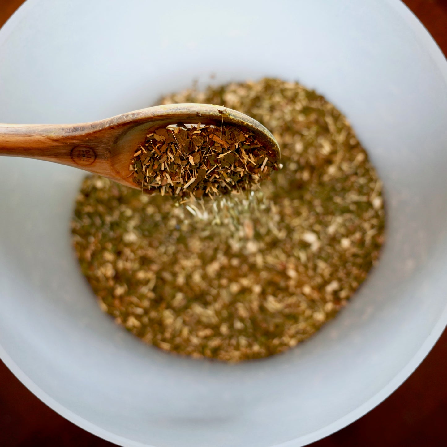 Cognitive Blissonance Herbs in Crystal Singing Bowl Being Mixed With a Wooden Spoon