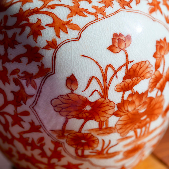 Macro photo of handpainted orange flowers on white Japanese porcelain vase.