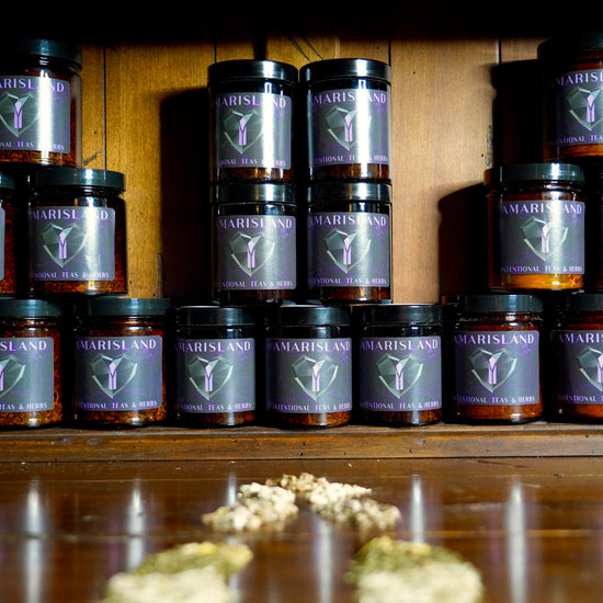 Jars of Amarisland Herbal Tea Blends lined up on Wooden Background
